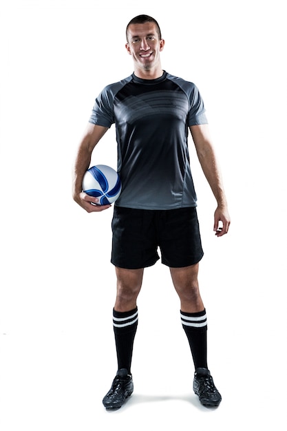 Portrait de pleine longueur de joueur de rugby souriant en tenue de ballon jersey noir