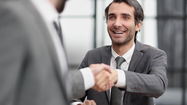 Portrait d'une poignée de main de jeune manager joyeux avec un nouvel employé