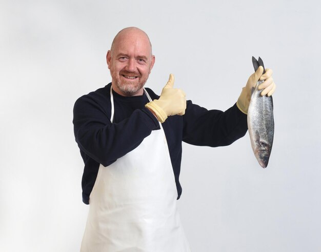 Portrait d'un poissonnier tenant et coup de pouce à un bar sur fond blanc