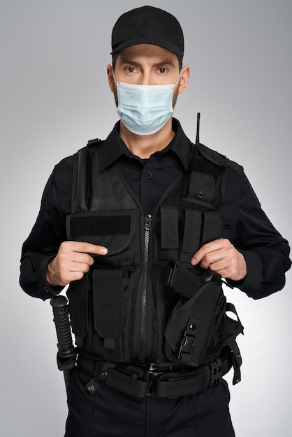 Portrait d'un policier confiant en tenue complète posant en studio