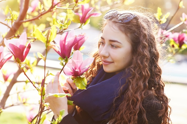 Portrait de printemps d'une belle femme sentant la fleur de magnolia