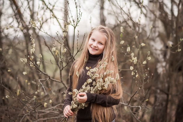 Portrait de printemps d'une belle fille avec un saule fleuri