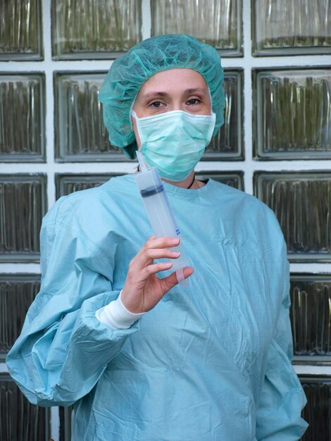 Photo portrait d'un professionnel de la santé tenant une seringue