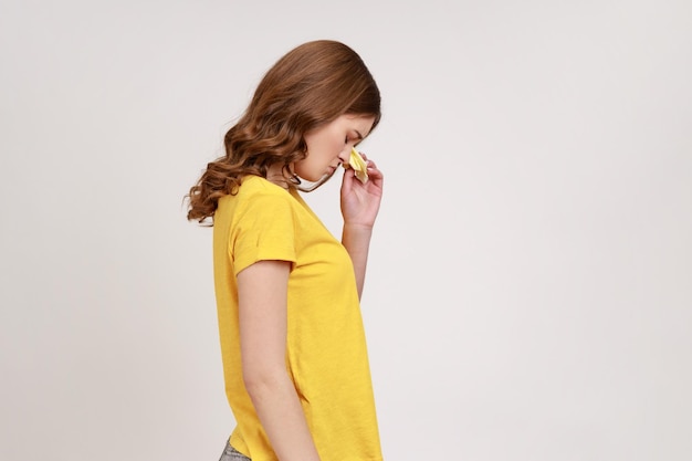 Portrait de profil d'une adolescente aux cheveux ondulés en T-shirt jaune exprimant la tristesse et la dépression contrariée par une femme pleurant des sentiments tristes désespérés Studio d'intérieur tourné isolé sur fond gris