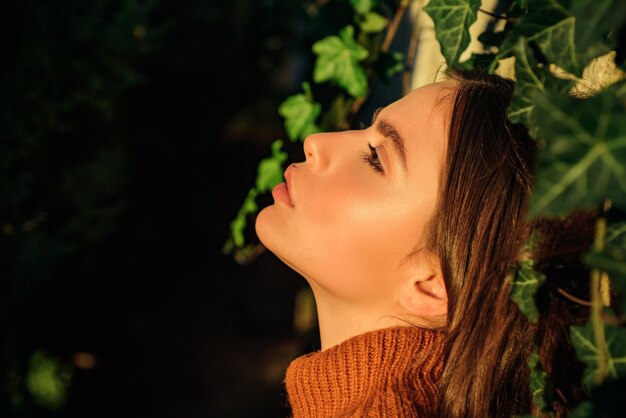 Portrait de profil d'un beau modèle avec un maquillage naturel et une peau parfaitement lisse capturant la dernière lumière du soleil. Reine d'automne. Bouchent le portrait d'une femme brune sexy.