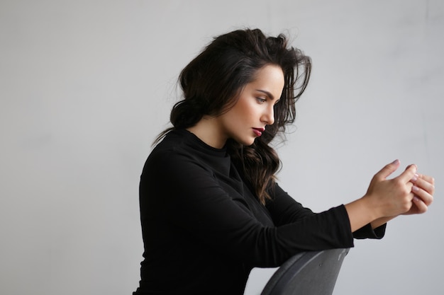 Portrait de profil d'une belle fille brune isolée dans un studio