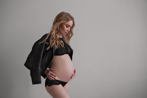 Portrait profil femme enceinte isolé fond gris beau mannequin en sous-vêtements noirs