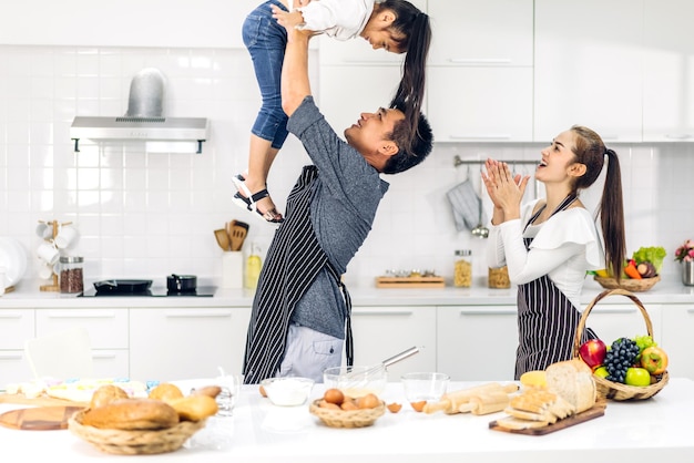 Portrait De Profiter De L'amour Heureux Famille Asiatique Père Et Mère Avec Petite Fille Asiatique Fille Enfant Jouer Et S'amuser à Cuisiner Des Aliments Avec Des Biscuits Et Des Ingrédients De Gâteau Dans La Cuisine