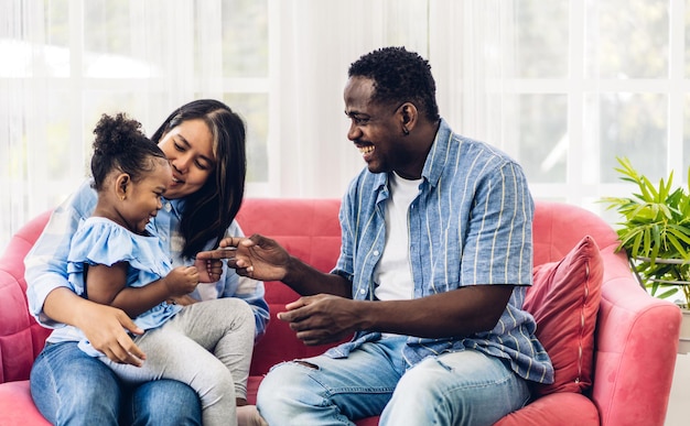 Portrait de profiter de l'amour heureux famille noire père et mère afro-américains avec petite fille africaine enfant souriant et jouer s'amusant moments bon moment dans la chambre à la maison