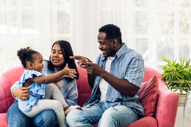 Portrait de profiter de l'amour heureux famille noire père et mère afro-américains avec petite fille africaine enfant souriant et jouer s'amusant moments bon moment dans la chambre à la maison