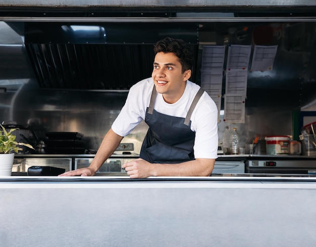 Portrait d'un propriétaire de camion de nourriture Jeune homme travaillant comme cuisinier dans un camion de nourriture