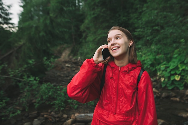 Portrait de randonneur souriant portant un imperméable rouge