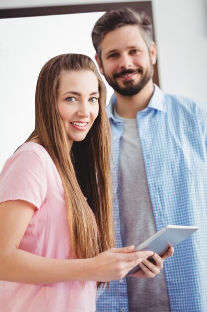 Portrait de rédacteurs heureux avec tablette numérique au bureau créatif