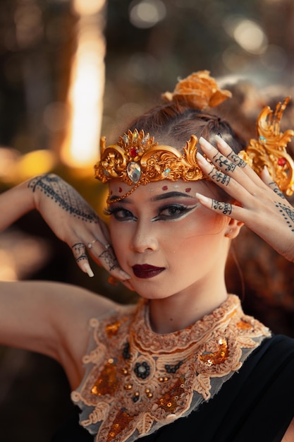 Portrait d'une reine dans sa couronne d'or et un collier d'or avec du maquillage sur son visage souriant