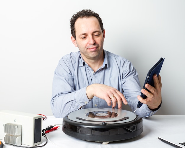 Portrait de réparateur professionnel changeant les batteries sur robot aspirateur