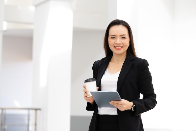 Portrait de réussite d'une femme d'affaires asiatique d'âge moyen Holding tablet smiling to camera