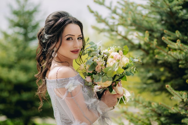 Photo portrait de rêve naturel d'une jolie demoiselle d'honneur souriante debout à côté du pin