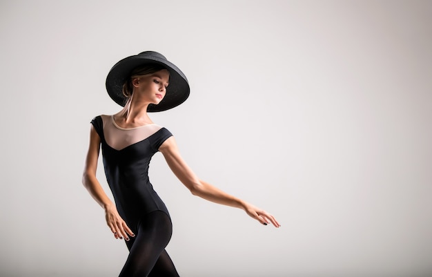 Portrait romantique d'une belle jeune fille sur fond clair dans un élégant chapeau