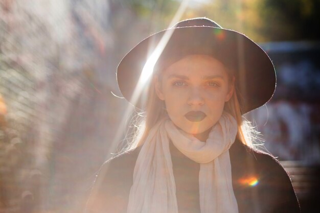 Portrait de rue d'une belle femme blonde posant avec des reflets dorés du soleil. Espace pour le texte