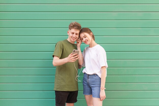 Le portrait de rue d'un couple heureux est sur un turquoise