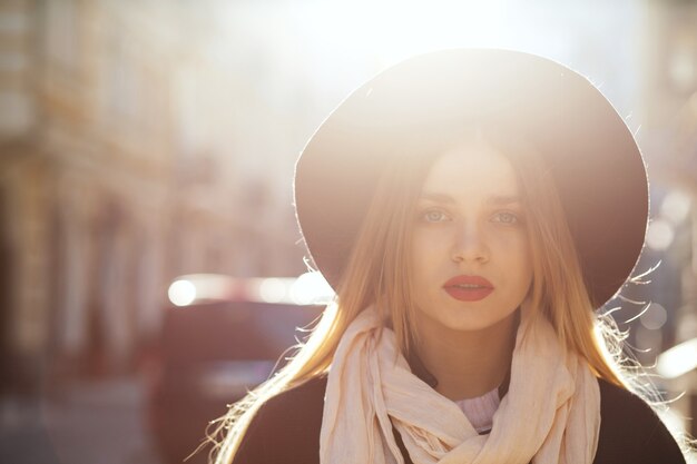 Photo portrait de rue d'une femme blonde glamour portant un chapeau et un manteau