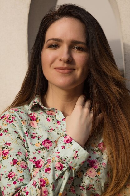 Portrait de rue d'une magnifique femme brune avec un beau maquillage posant au coucher du soleil