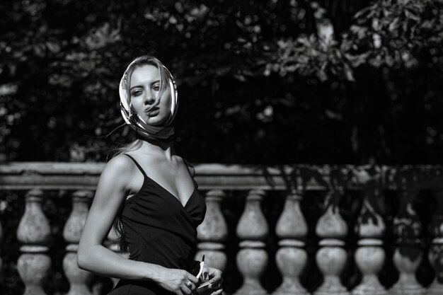 Portrait de rue d'un mannequin blond séduisant porte une robe et un châle. Une femme marche en journée ensoleillée dans la rue à Kiev. Tonification monochrome. Espace pour le texte