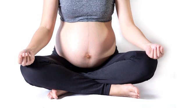 portrait de la section médiane d'une femme méconnaissable au cours des derniers mois de la grossesse tenant son gros ventre