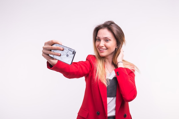 Portrait de selfie faisant belle jeune femme en veste rouge