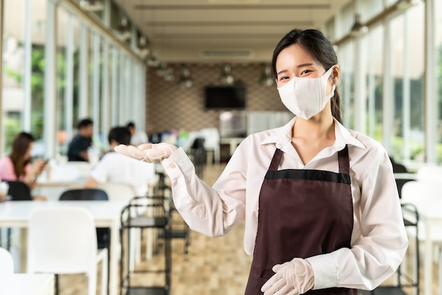 Portrait de serveuse asiatique attrayante porter un masque facial. Nouveau concept de style de vie de restaurant normal.