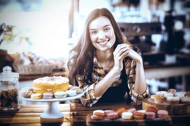 Portrait de serveuse debout au comptoir avec desserts