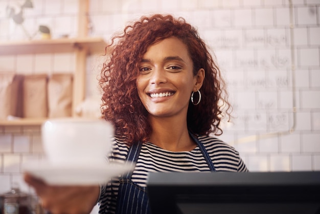 Portrait d'une serveuse heureuse et d'une tasse de café dans un café-restaurant et une industrie de la restauration