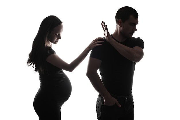 Portrait silhouette noir et blanc d'un homme et d'une femme enceinte, silhouette de couple marié, concept de grossesse non désirée, départ de la famille, divorce