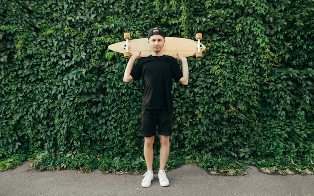 Portrait de skateur se dresse sur le mur avec de la vigne