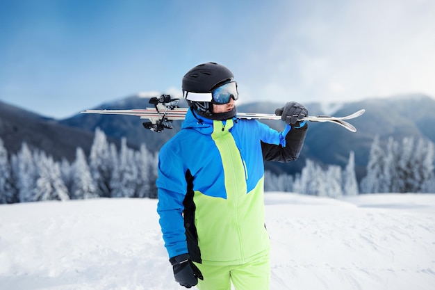 Portrait d'un skieur dans la station de ski sur le fond des montagnes et du ciel bleu Bukovel lunettes de ski d'un homme portant des lunettes de ski Sports d'hiver