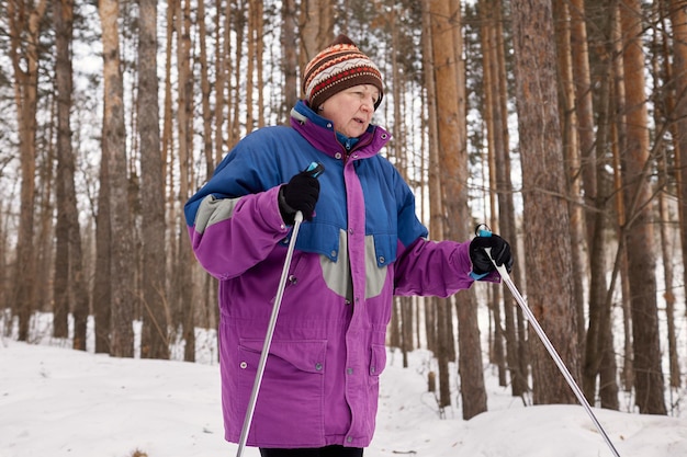 Portrait d'un skieur senior dans une forêt d'hiver