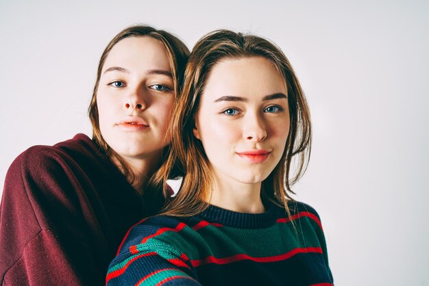 Portrait de sœurs souriantes portant des vêtements chauds sur un fond blanc