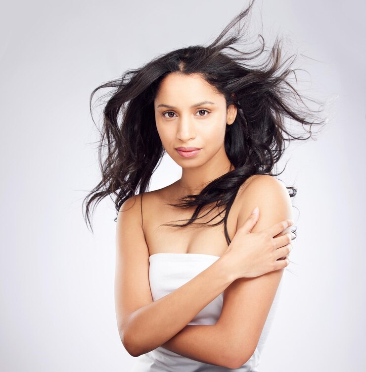 Photo portrait de soins capillaires et de femme avec brise dermatologie et cosmétiques sur fond de studio blanc face personne et modèle avec texture de volume et vent avec soin de routine traitement de kératine ou brillance