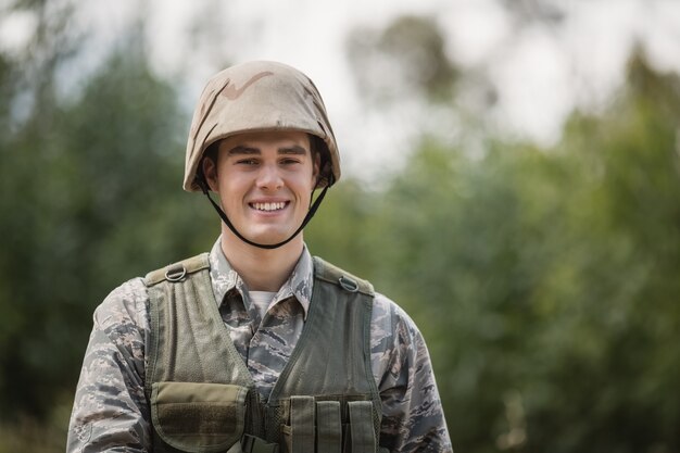 Portrait de soldat militaire souriant dans le camp d'entraînement