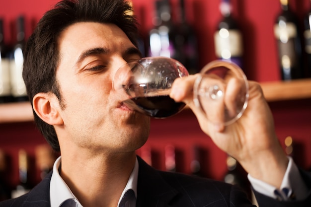 Portrait d&#39;un sommelier dégustant un verre de vin