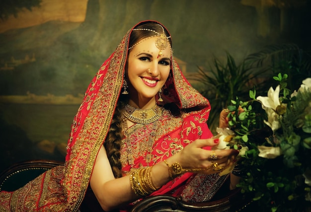 Portrait souriant d'une belle fille indienne à la maison Modèle de jeune femme avec ensemble de bijoux en or