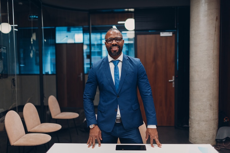 Photo portrait souriant homme d'affaires afro-américain en costume bleu au bureau