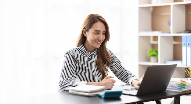 Portrait de souriante belle femme d'affaires asiatique travaillant au bureau utilise un ordinateur avec un espace de copie propriétaire d'entreprise personnes sme freelance marketing en ligne e-commerce télémarketing travail à domicile concept