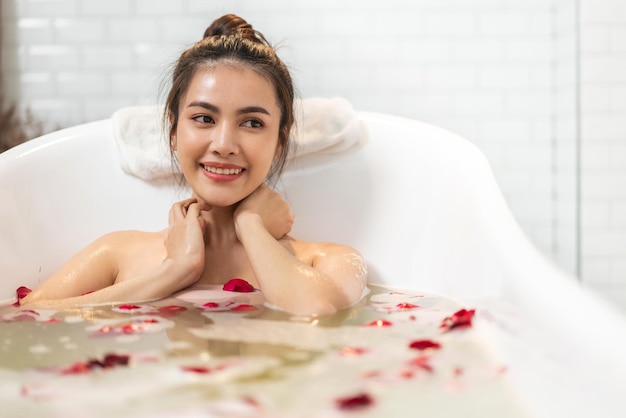 Photo portrait de sourire de beauté heureuse jolie femme asiatique propre traitement de spa peau blanche fraîche et saine profiter de la détente en prenant une douche et un bain avec un spa en mousse à bulles dans la baignoire de la salle de bain