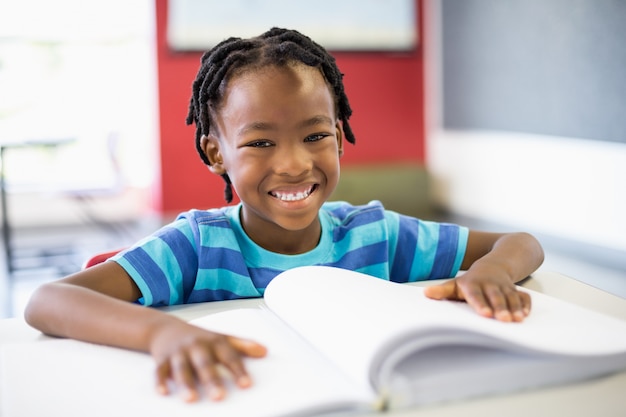 Portrait, de, sourire, écolier, livre lecture, dans, classe