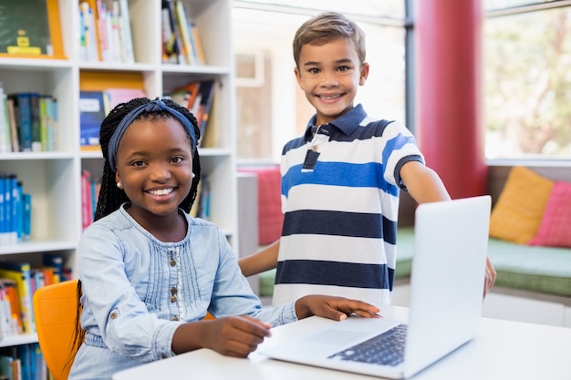 Portrait, de, sourire, écoliers, utilisation, a, ordinateur portable, dans, bibliothèque