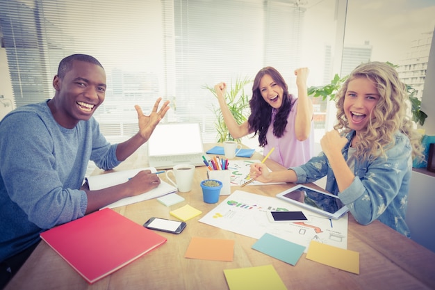 Photo portrait de sourire des gens d'affaires gesticulant assis au bureau