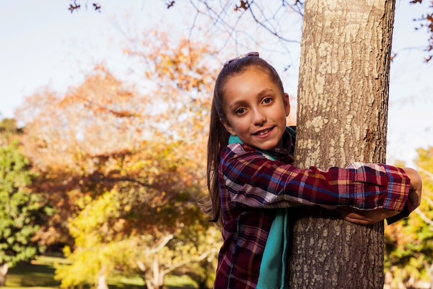 Portrait, de, sourire, girl, étreindre, arbre