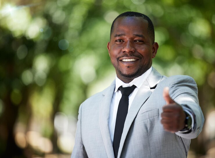 Photo portrait sourire et homme d'affaires heureux avec le pouce levé pour l'objectif de réalisation et le succès dans son travail d'entreprise en plein air dans un parc employé avec signe de la main ou icône pour remercier le gagnant et voter