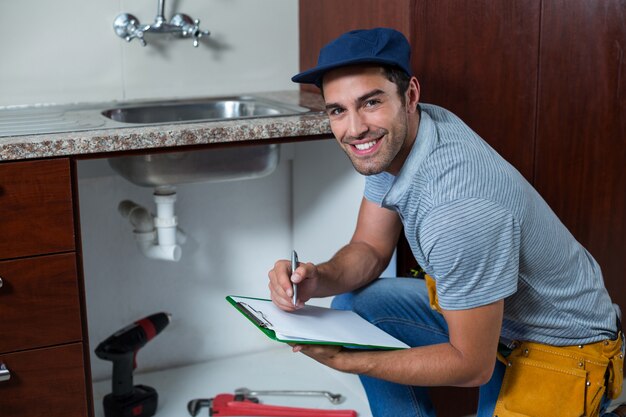 Portrait, sourire, homme, écriture, presse-papiers